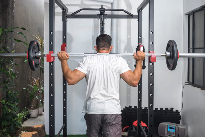 Man squatting in power rack