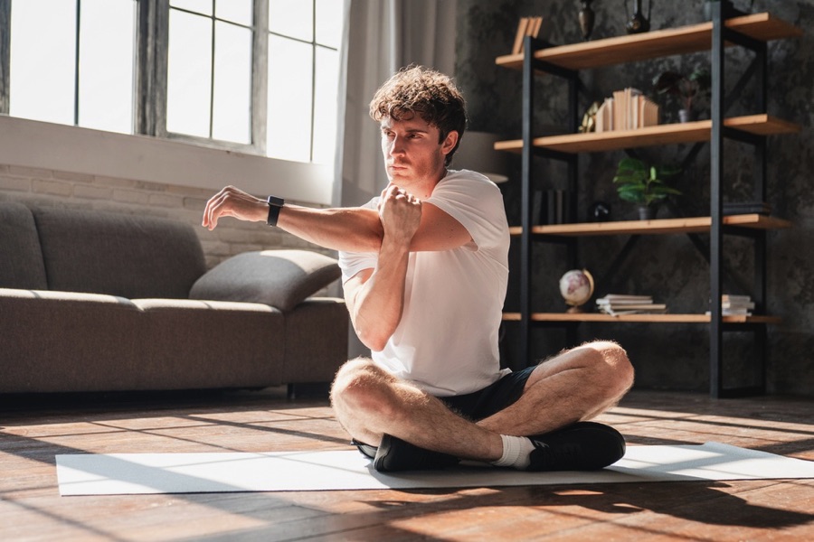 Man stretching at home on mat