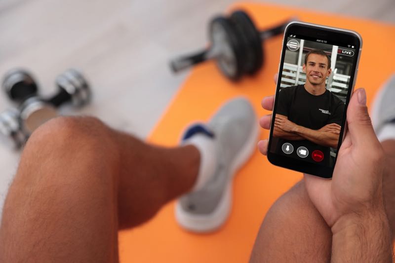 Man video calling man at gym